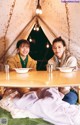 Two women sitting at a table in a tent.