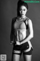 A woman in a sports bra top and shorts posing for a picture.