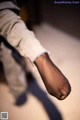 A close up of a person's foot with a shadow on the ground.