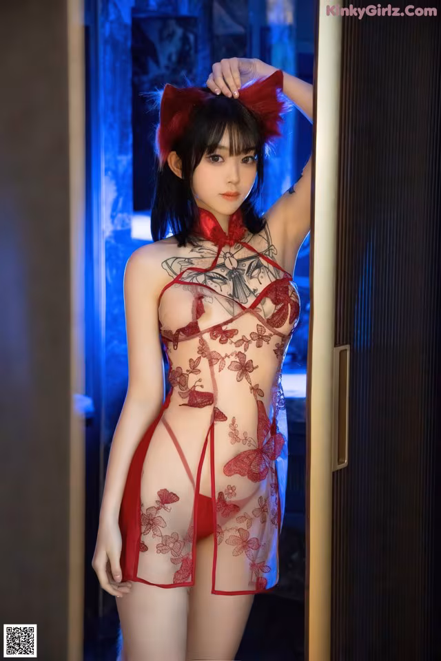 A woman in a red lingerie posing for the camera.