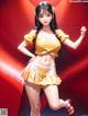 A woman in a yellow top and skirt posing for a picture.