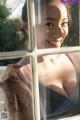 A woman looking out of a window at the sun.