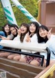 A group of young women sitting on top of a roller coaster.