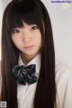 A young woman with long brown hair wearing a bow tie.
