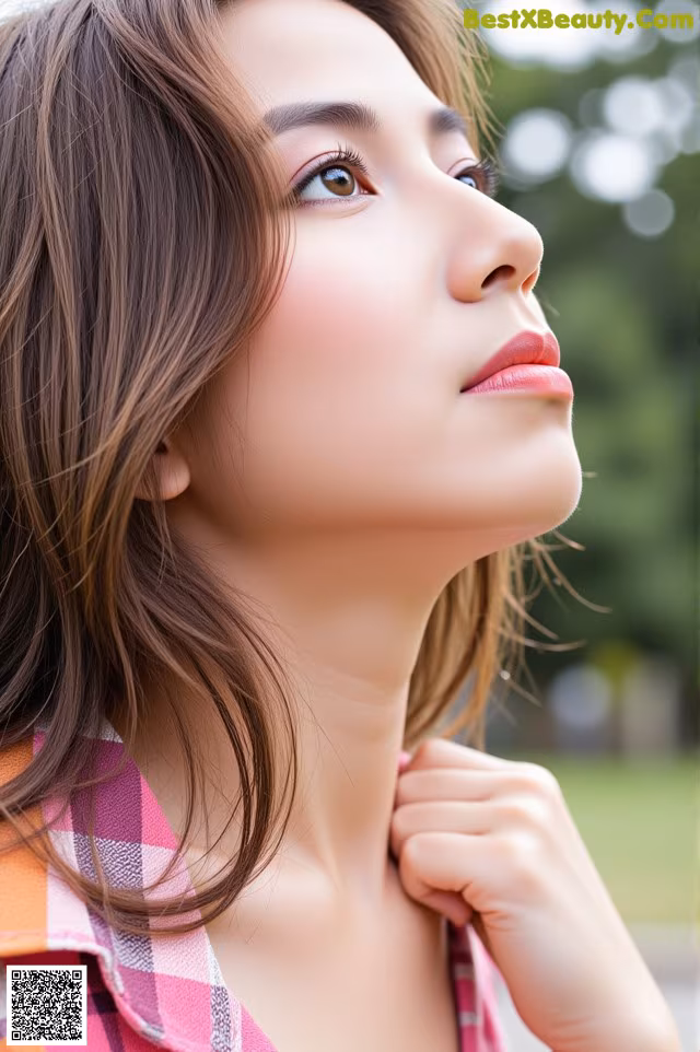 A woman with long brown hair wearing a plaid shirt.