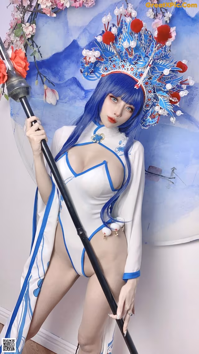 A woman in a blue and white outfit holding a sword.